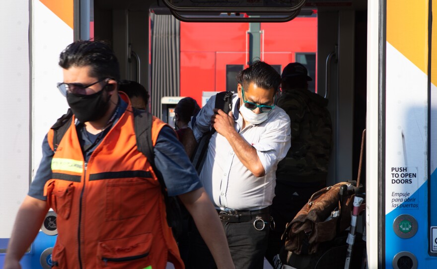 Riders exit a Blue Line trolley at the San Ysidro Transit Center, June 17, 2021.