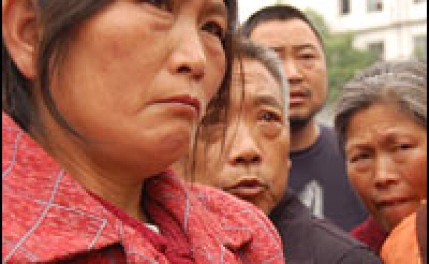 Wang Suhua (left) lost her granddaughter in the earthquake. She says Yang Miao was found in the rubble of the school, holding a pen in her hand.