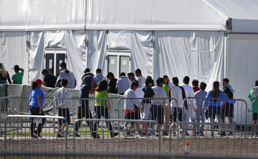 Migrant children line up to enter a tent at the Homestead Temporary Shelter for Unaccompanied Children in Homestead, Fla. in February 2019.