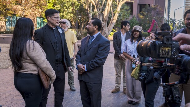 Norberto Ambrosio (center) talking to Father Scott Santarosa in front of the Edward J. Schwartz federal building as his daughter, Sofia Sanchez, looks on, Nov. 25, 2025.