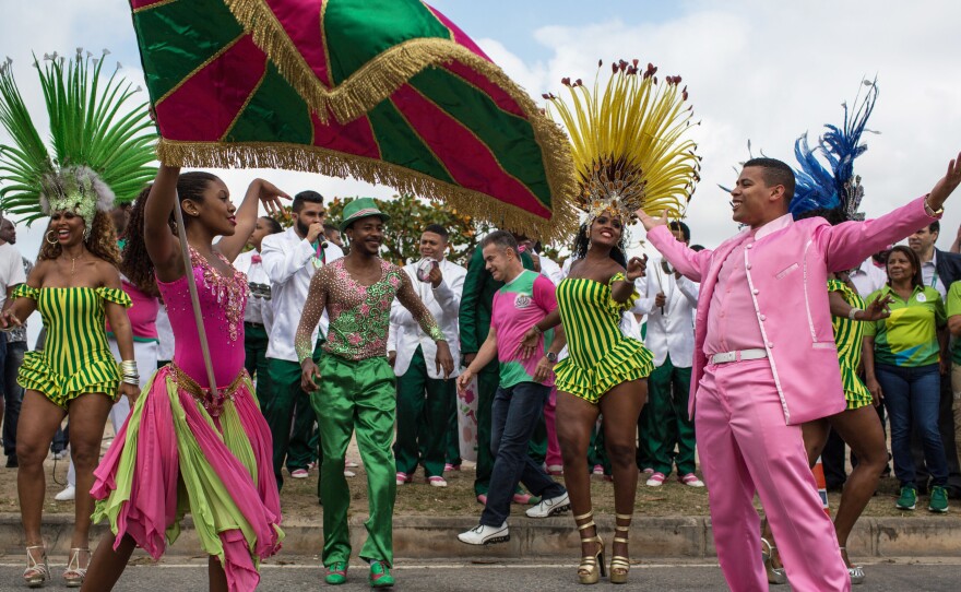 Dancers from the Mangueira samba school perform in the street Thursday while waiting for the arrival of the Olympic flame ahead of the games, which open Friday in Rio de Janeiro. The flame will be carried through the streets of Rio to Maracana Stadium for Friday night's opening ceremony.