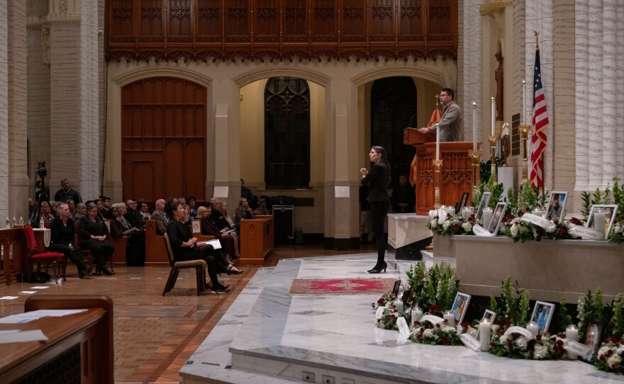 Rev. Allen Austin of Pathway Vineyard Church, right, speaks at the OneLewiston Community Vigil in the Basilica of Saints Peter and Paul in Lewiston, Maine. Regan Thibodeau, second from right, interprets Little's remarks into American Sign Language.