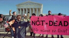 A sign reads "Not Dead. We want to live." With gripping stories and a personal mission, "Life After" explores who gets real choice, and who doesn't, in life and death.