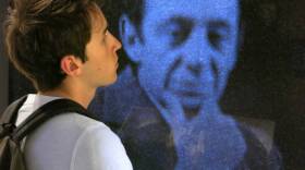 A visitor to the GLBT Historical Society Museum listens intently to the recorded will of Harvey Milk, the first openly gay member of the San Francisco Board of Supervisors, who was assassinated in 1978. 