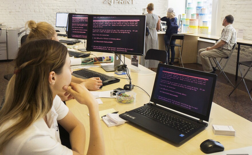 Employees at a store in Kiev, Ukraine, read a ransomware demand for $300 in bitcoin to free files encrypted by the Petya software virus. The malicious program has spread to dozens of countries.