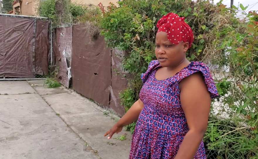 Carolina Festo surveys the concrete outside her City Heights home, where she'd like to add fake grass to make it safe for kids, May 3, 2022.