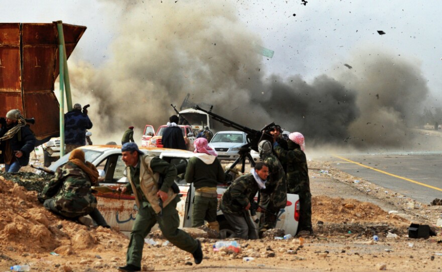 Shrapnel flies through the air as a tank shell explodes near Libyan rebel fighters defending their last position against Gadhafi's loyalist forces at Ras Lanuf on Thursday.