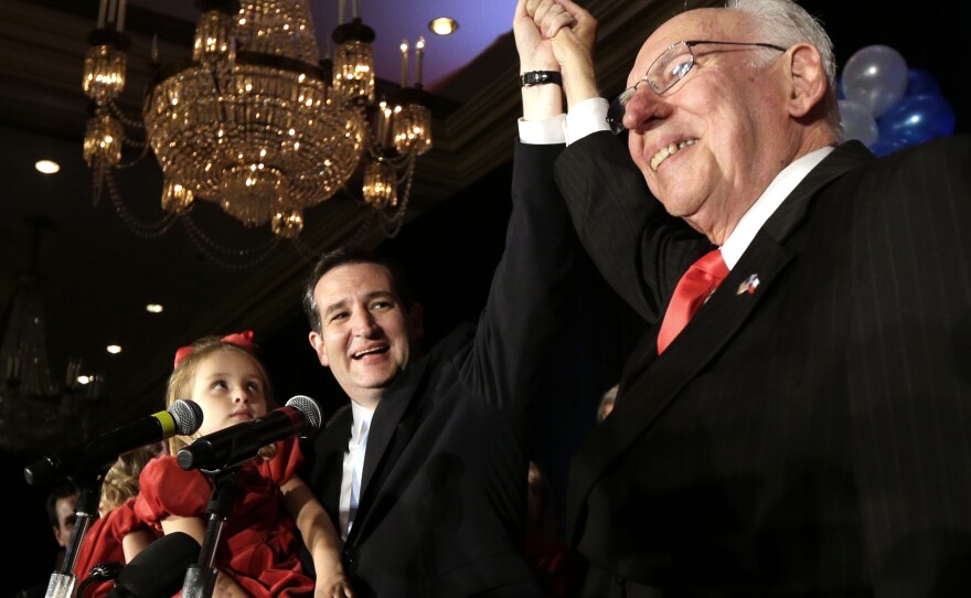 Republican Ted Cruz, left, raises his hand with his father Rafael, right, while holding his daughter Caroline during a victory speech in November 2012.