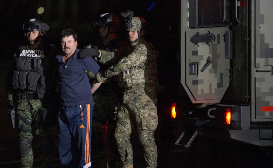 Mexican drug lord Joaquin "El Chapo" Guzman is escorted by army soldiers to a waiting helicopter, at a federal hangar in Mexico City Friday. The world's most wanted drug lord was recaptured six months after he fled through a tunnel from a maximum security prison in a made-for-Hollywood escape that deeply embarrassed the government and strained ties with the United States.