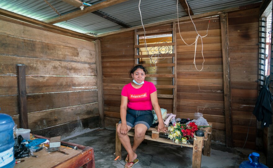 Polly Persaud, Chandroutie's daughter-in-law, lived for two weeks in knee-high water before moving with her children into a shelter. Here, she sits on one of the many structures she fashioned to hold things above the water. She and her husband would take turns watching the floodwaters, never sleeping at the same time, to make sure they didn't rise more.
