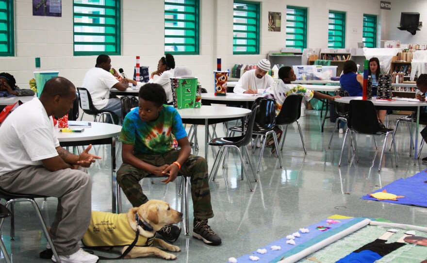 The campers share a table with their fathers where they can catch up and work on crafts. Kobe Goodall and his dad, Carlos Goodall, talked a lot about football this year. Kobe wants to try out for his high school team. Carlos Goodall is serving 13 years in prison for robbery and drug possession.