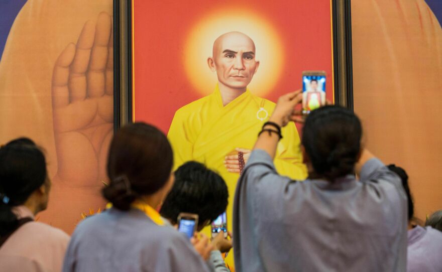 People take pictures of a portrait of Thich Quang Duc, the monk who set himself on fire on a busy Saigon street corner in 1963, at the Vietnam Quoc Tu pagoda in Ho Chi Minh City on June 3, 2018. Vietnam marked the 55th anniversary of the self-immolation by the monk whose fiery protest came to symbolize the repression of the U.S.-backed South Vietnamese regime against Buddhism.