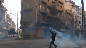 The Syrian uprising began a year ago. Here, a protester in Homs throws a tear gas canister back at security forces on Dec. 27, 2011.