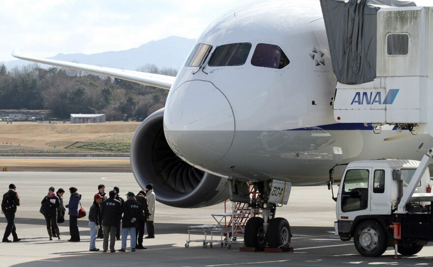 National Transportation Safety Board investigators inspect a Boeing 787 Dreamliner at Japan's Takamatsu Airport. A Federal Aviation Administration investigation into the plane's troubles has widened into a review of the agency's certification process for new airliners.