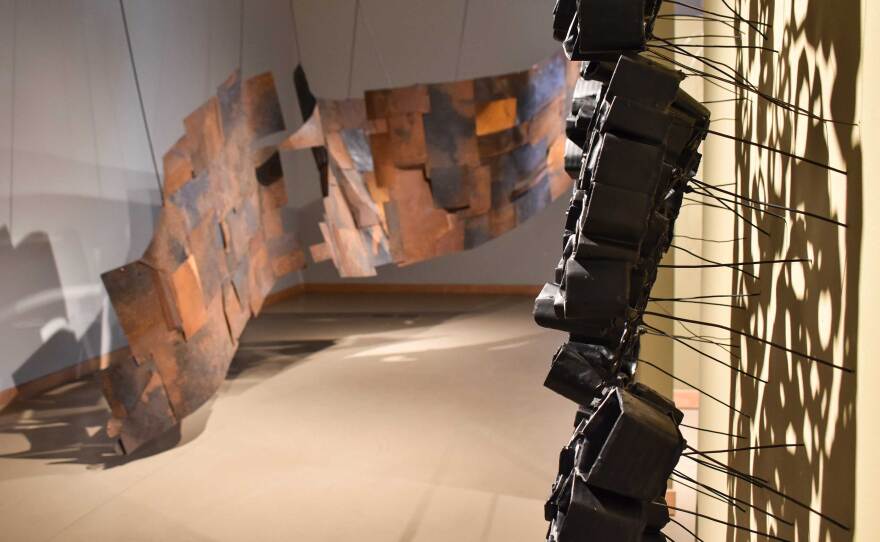 Two of Kline Swonger's sculptural works are installed in the Cannon Gallery in an undated photograph. In the foreground is "Above and Below," and the massive steel-based piece "Crossing the Line" is shown in the background.