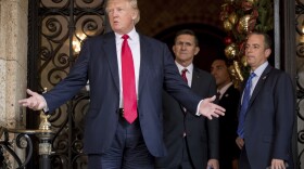 President-elect Donald Trump, left, accompanied by Trump Chief of Staff Reince Priebus, right, and Retired Gen. Michael Flynn, a senior adviser to Trump, center, speaks to members of the media at Mar-a-Lago, in Palm Beach, Fla., Wednesday, Dec. 21, 2016. 