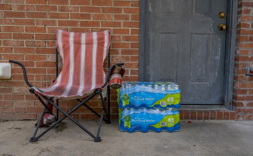 Water bottles donated by the Salvation Army are placed outside of an apartment.
