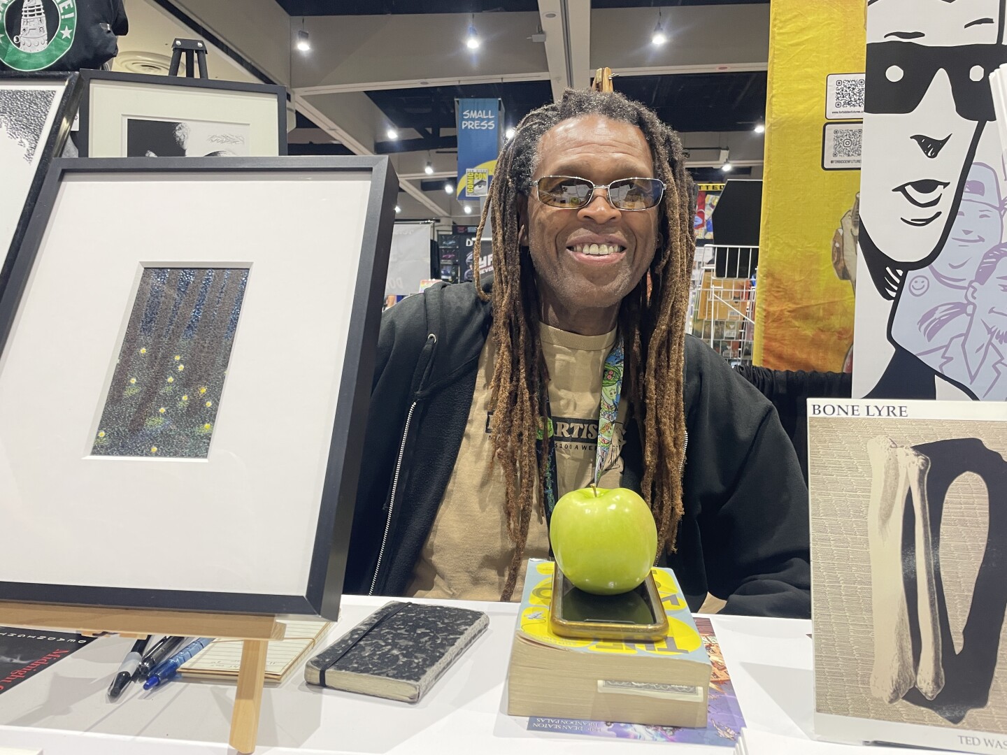 San Diego comic book artist and poet Ted Washington shows what remains of his Comic-Con survival supplies as the exhibit hall closed on Thursday, July 24, 2025: A book of translated science fiction short stories from around the world and an apple.