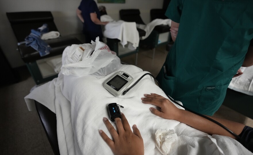 A medical student, right, and nurse, back, monitor women as they rest before and after getting abortions, Saturday, Oct. 9, 2021, at Hope Medical Group for Women in Shreveport, La. The nation's most restrictive abortion law is driving many women from Texas to seek services in neighboring states.