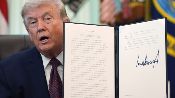 President Trump holds his signed executive order that calls for restricting voting by mail in the White House's Oval Office in March.