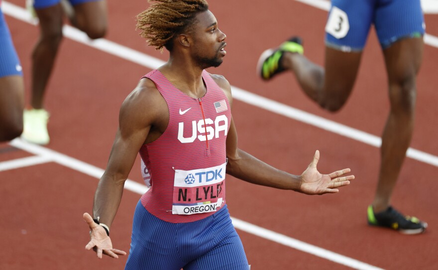 Noah Lyles celebrates winning gold in the men's 200m — and checks his record time — at the World Athletics Championships at Hayward Field in Eugene, Ore.