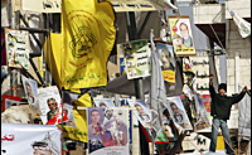 A Palestinian boy waves in West Bank's Manara square, which is filled with flags and campaign posters, Jan. 23.