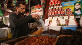 An Iraqi shop owner sells groceries in Baghdad. World Bank President Robert Zoellick says the high cost of food is an "aggravating factor" behind the unrest in the Middle East.
