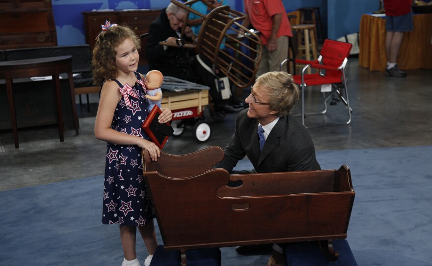 Leslie Keno (right) appraises an 18th-century American walnut cradle in Raleigh, NC. ANTIQUES ROADSHOW “Vintage Raleigh 2025, Hour 1” airs Monday, September 29 at 8/7C PM on PBS.