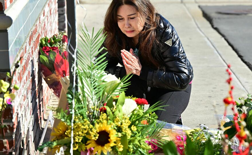 A woman who lost many friends in the Jan. 21 shooting in Monterey Park, Calif., grieves at a makeshift memorial outside the Star Ballroom Dance Studio.