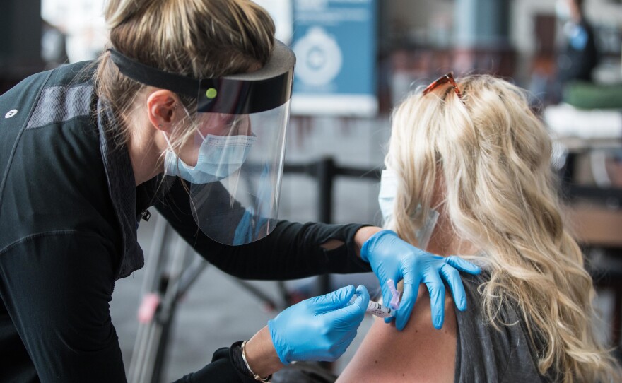 A woman receives the COVID-19 vaccine at Gillette Stadium on Jan. 15, in Foxborough, Mass. Setting up community vaccination centers will be a key to getting the vaccine to millions, an adviser to President Biden says.