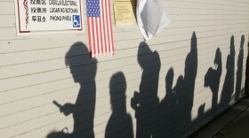 The rising sun casts shadows of voters waiting to vote at a polling place in Los Angeles, Nov. 4, 2008.