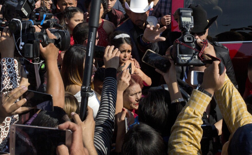 Journalists surround Rubi Ibarra as she arrives at the site of a Mass during her 15th birthday party. Her daylong celebration was reportedly attended by thousands, and for some portions tens of thousands, of people.