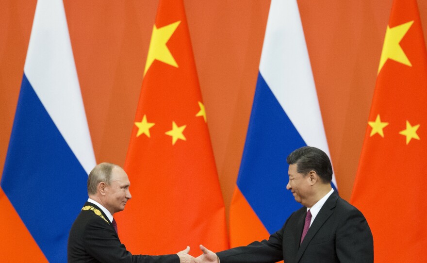 Chinese President Xi Jinping, right, and Russian President Vladimir Putin shake hands during an awarding ceremony at the Great Hall of the People in Beijing, China, on June 8, 2018. Xi is traveling to Moscow to show support for Putin.