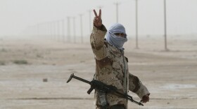 A Libyan rebel soldier flashes the "V for victory" sign as he prepares for battle in the eastern city of Ajdabiya on Wednesday.
