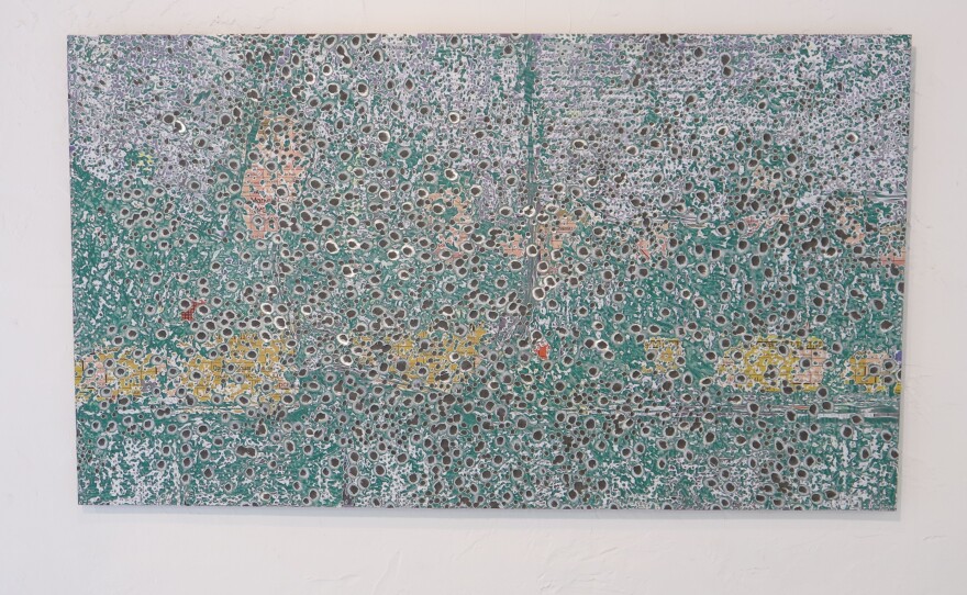 Artist Oleksiy Sai created an image of the Donbas region of Ukraine, then ground "bomb craters" into the surface.