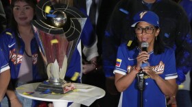Venezuela's acting President Delcy Rodriguez, right, speaks next to the World Baseball Classic trophy a day after her team's victory over the United States in the championship match, at Miraflores presidential palace in Caracas, Venezuela, Wednesday, March 18, 2026.