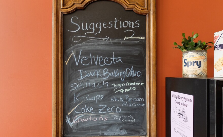 Customers can request grocery items on this chalkboard hanging on the wall.