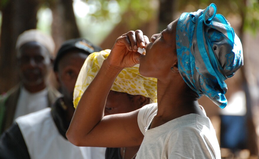 A woman in Guinea takes her first dose of the two-stage  vaccine Shanchol during the country's 2012 epidemic.