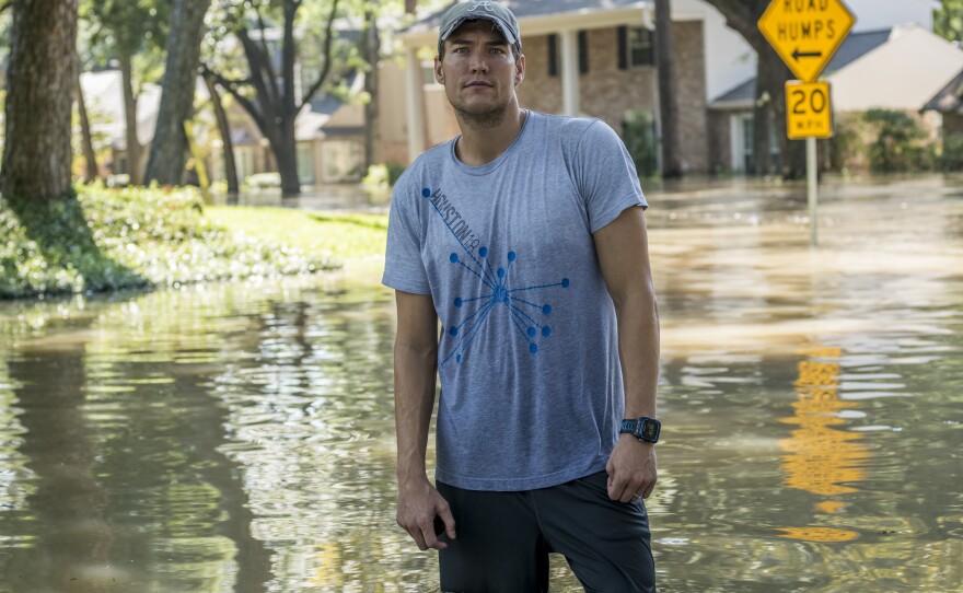 Jared McCurley walks through the flooded streets near his home in the Nottingham Forrest subdivision.