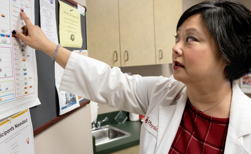 Dr. Michelle Salvaggio, medical director of the Infectious Diseases Institute at the University of Oklahoma Health Sciences Center in Oklahoma City, points to drugs used to treat HIV/AIDS. Medical advancements since the epidemic surfaced in the 1980s have helped many of her HIV-positive patients lead healthy lives.