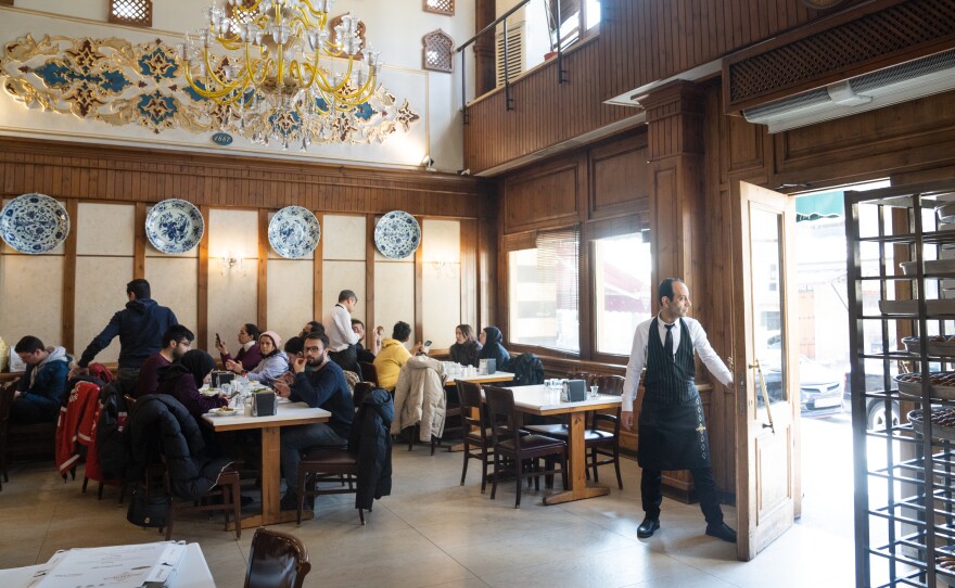 A server opens the door for customers at Imam Cagdas.