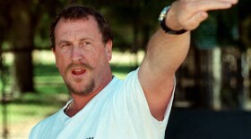 In this April 26, 1997, file photo, George Holliday points to the spot along a roadside in the Lake View Terrace section of Los Angeles where he videotaped Rodney King being beaten in April 1992, during a news conference in Los Angeles.