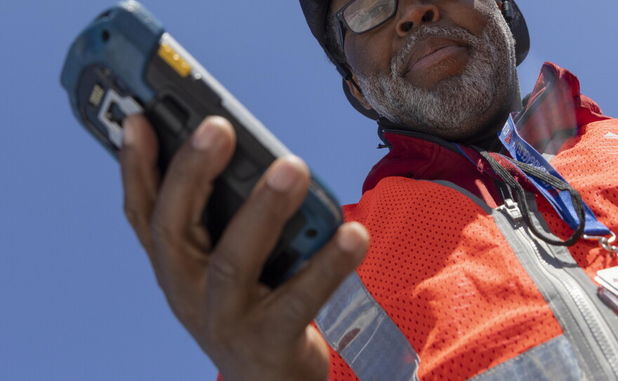 Delta Air Lines ramp agent Mike Davis uses a handheld electronic scanner with Delta's Radio Frequency Identification and Artificial Intelligence technology to locate passenger luggage after unloading from a plane at Hartsfield-Jackson Atlanta International Airport.