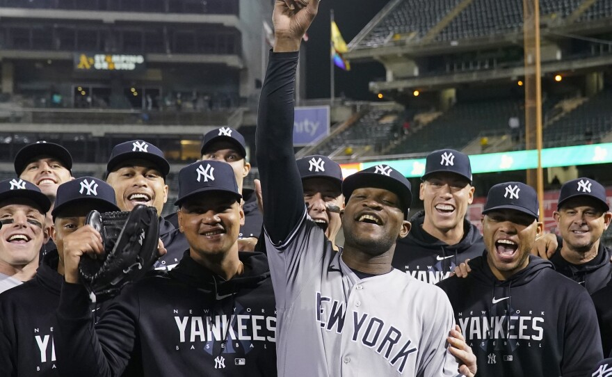 New York Yankees pitcher Domingo Germán, center, poses for a photograph with the team after his perfect game against the Oakland Athletics during a baseball game in Oakland, Calif., Wednesday, June 28, 2023.