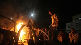 Palestinians gather around a vehicle struck by an Israeli strike in Gaza City, Friday, May 15, 2026.
