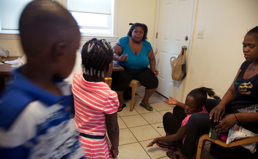 Michelle Williams (center), at home in Dorchester, Mass., talks with grandchildren Ayniah Williams (pink dress) and Drequain Smith (far left). At right are her daughters Vanessa "Nessa" Williams (far right) and Margaret Williams. Both Michelle and Ayniah had latent TB infections and have been treated.