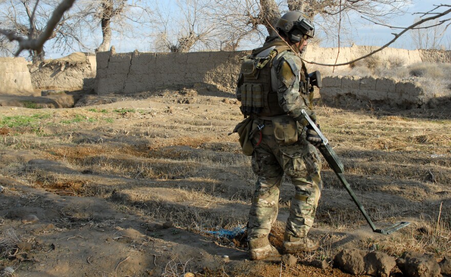 A U.S. Navy explosives ordnance disposal technician clears an area of explosives during operations March 2011, in Zharay District, Kandahar Province, Afghanistan.