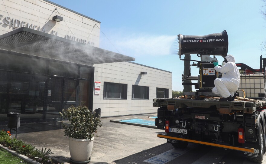 The Spanish Ministry of Health says the country has 47,610 coronavirus cases — and more than 3,400 people have died from COVID-19. Here, a member of the Emergency Military Unit disinfects buildings in Getafe.