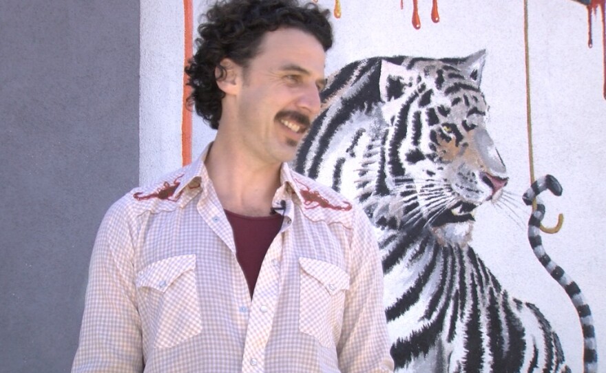 Michael Summers stands next to his tiger mural in Carlsbad, March 28, 2017.