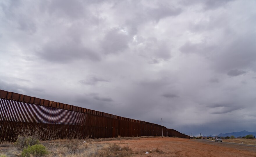 The border wall extends as far as the eye can see from downtown Naco, Ariz.